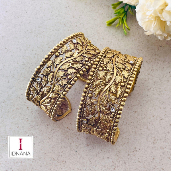 A PAIR OF GOLD PLATED FLORAL DESIGN KUNDAN STUDDED HANDCUFFS