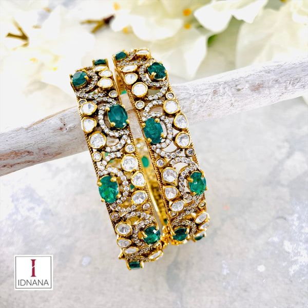 A PAIR OF GOLD PLATED EMERALD MOISSANITE CZ BANGLES SIZE 2.4 OPENABLE