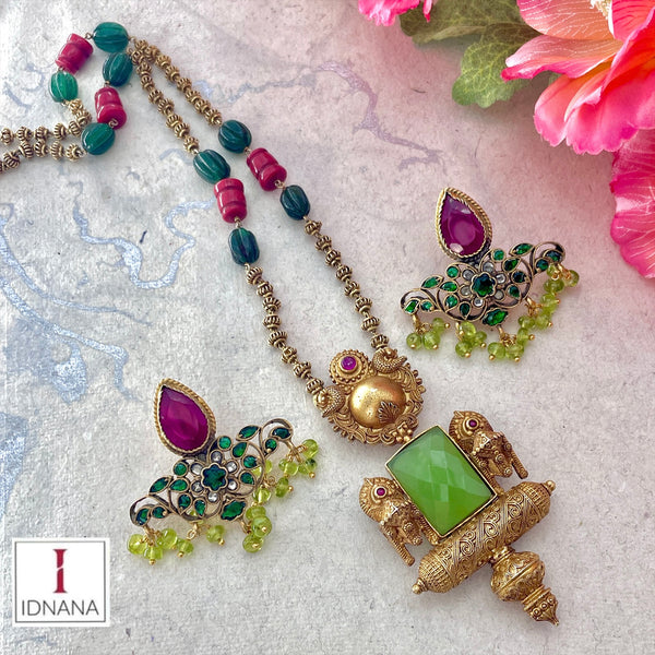 GOLD PLATED FACETED LIGHT GREEN CHALCEDONY AMULET AND LINGAM MOTIF GOLD PLATED LONG NECKLACE WITH RUBY PERIDOT GREEN KUNDAN EARRINGS