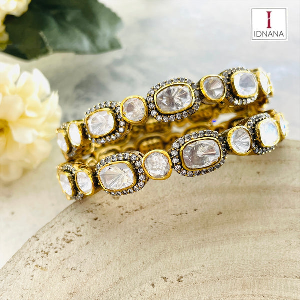 A PAIR OF GOLD PLATED MOISSANITE BANGLES (2.3 OPENABLE)